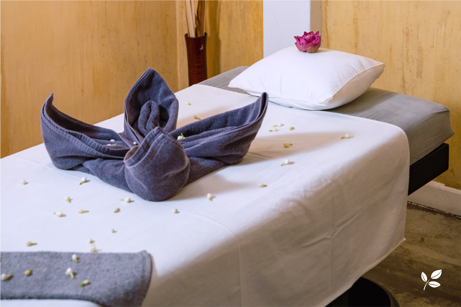 Table de massage et sa serviette piliée en forme de fleur