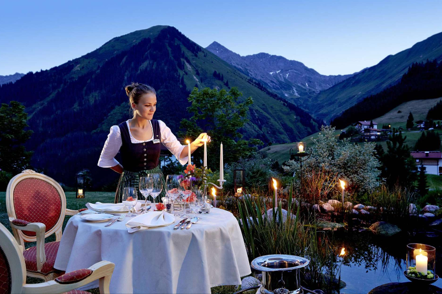Dîner romantique aux chandelles dans un jardin des Alpes - ©Hotel Singer - Relais & Châteaux, Berwang -