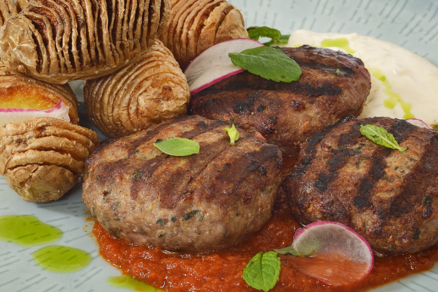 Minced beef meatballs stuffed with feta cheese PDO, tomato sauce & yogurt. Served with whole baked baby potatoes with fresh herbs