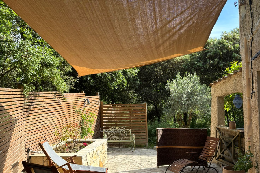 Extérieur privatif avec table et chaises, 3 transats, banc sous une voile d'ombrage