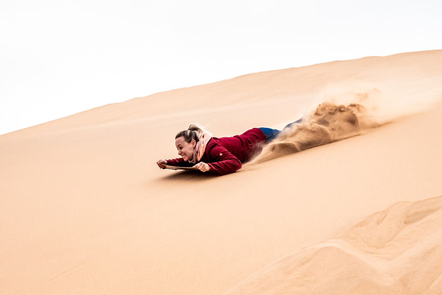 Lie-down sandboarding - a fun activity to try - ©Desert Explorers