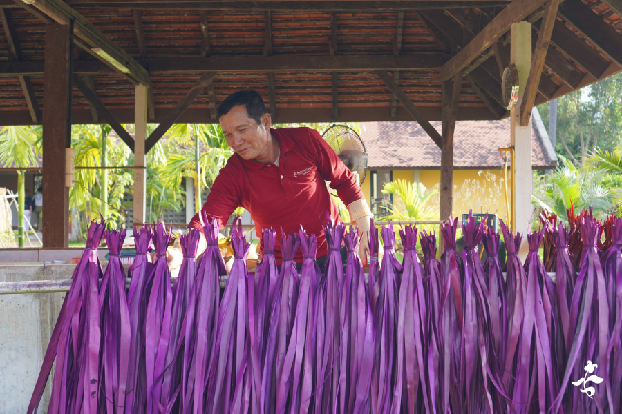Artisan dyes sugar palm leafs in purple colour