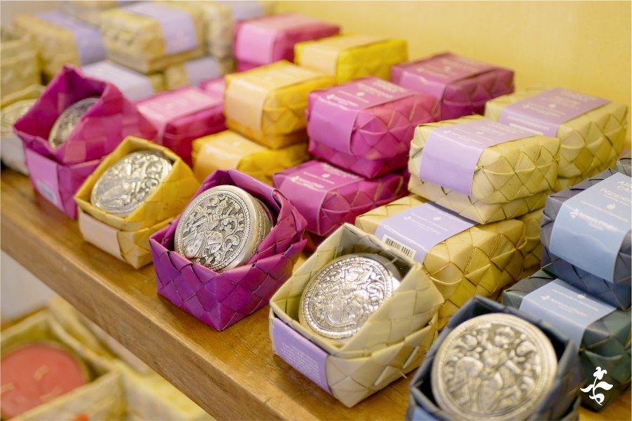 Candles in handmade silver boxes are displayed in the shop